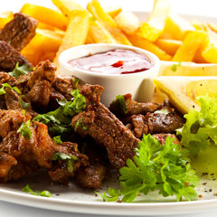 Grilled meat with French fries and vegetables
