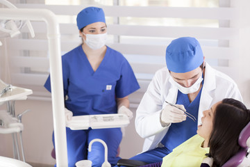 Obraz premium Dentist and assistant cleaning a patient's teeth