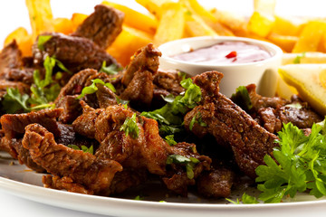 Grilled meat with French fries and vegetables