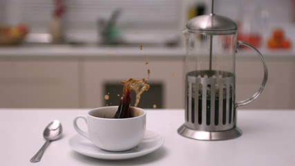 Sugar cube falling in coffee - Powered by Adobe