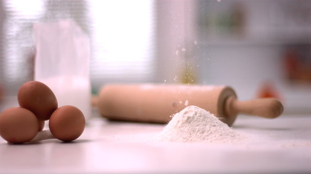 Flour sprinking on kitchen counter with baking tools