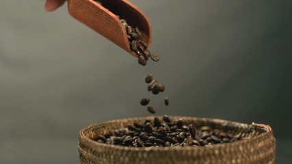 Hand pouring coffee beans from a wooden spoon in slow motion - Powered by Adobe