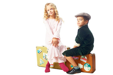 Kids sitting on a suitcases