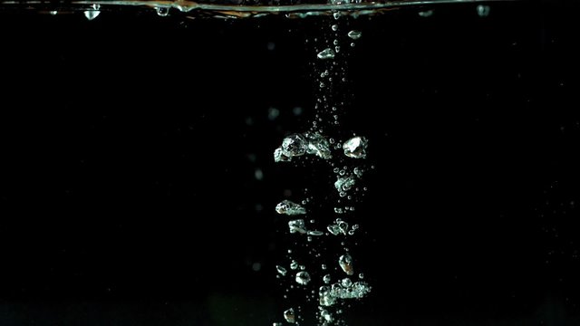 Lime dropping into water and floating in slow motion