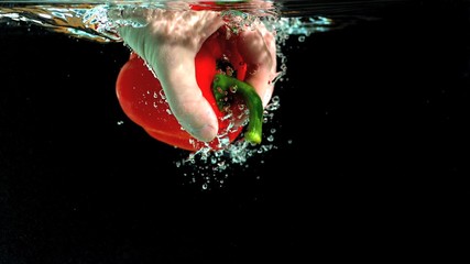 Hand taking red pepper from water in slow motion - Powered by Adobe