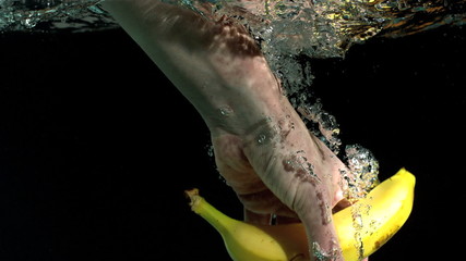 Hand taking a banana from water in slow motion - Powered by Adobe