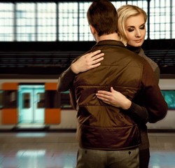 Beautiful couple embracing on train station