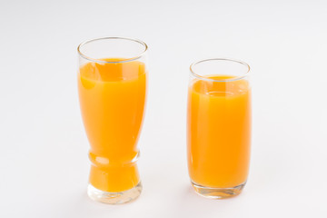 Glasses of orange juice on white background