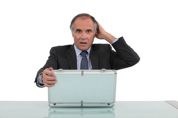 Shocked man looking in an aluminium briefcase