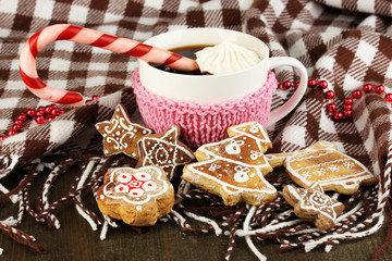 Cup of coffee with Christmas sweetness on plaid close-up