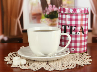Jar and cup of tea on table in room