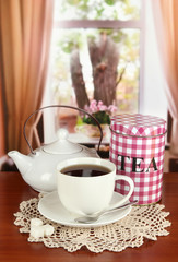 Jar and cup of tea on table in room