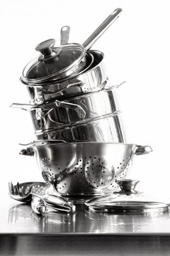 Stack With Stainless Steel Pots And Pans On White