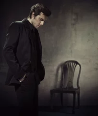 Fototapete Rund Handsome man in a business suit on a dark background © konradbak