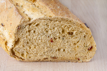 Loaf of mediterranean bread on wooden chopping board