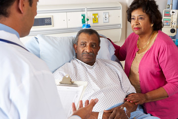 Doctor Talking To Senior Couple On Ward - Powered by Adobe