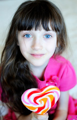 Little girl with heart-shaped candy