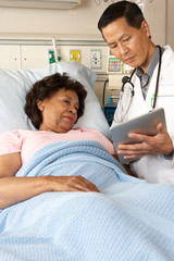 Obraz premium Doctor Using Digital Tablet Talking With Senior Patient