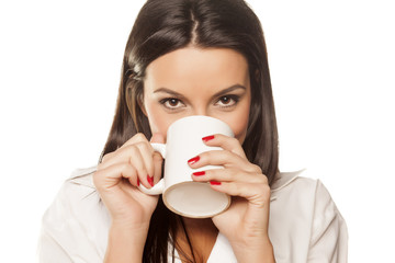 beautiful brunette in a white men's shirt drinking morning tea