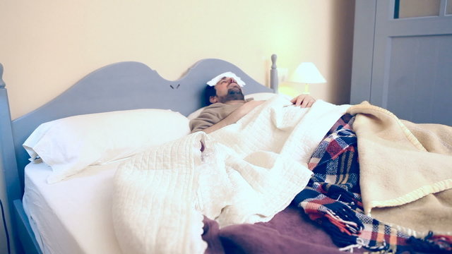 Man in bed with flu eats potato chips