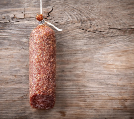 hanging salami sausage on wooden background