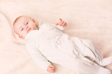 Portrait of a cute baby lying on a cover