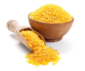 corn groats in a wooden bowl isolated on white © andriigorulko