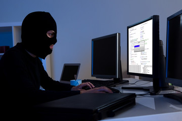 Hacker downloading information off a computer