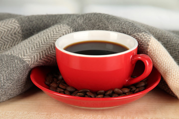 cup of coffee with scarf on table in room
