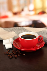 cup of coffee with scarf on table in room