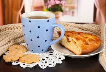 cup of tea with scarf on table in room