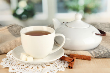 Fototapeta premium cup of tea with scarf on table in room