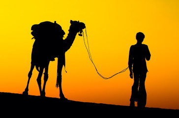 Silhouette man and camel at sunset, Jaisalmer - India