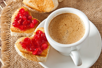 heart-shaped toast with jam and a cup of coffee 