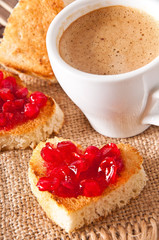 heart-shaped toast with jam and a cup of coffee 