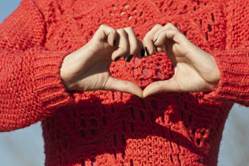 Heart shape made by hands of a young woman