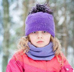 Little blond girl in winter forest