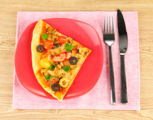plate with a slice of delicious pizza on wooden background