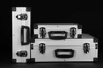 Silvery suitcases on black background