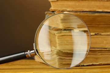 Magnifying glass and books on table