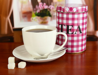 Jar and cup of tea on table in room