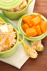 Taste rice porridge with pumpkin in saucepans