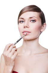 woman with cosmetic brush on lips