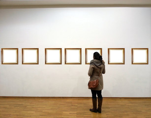 Woman in gallery room looking at empty frames