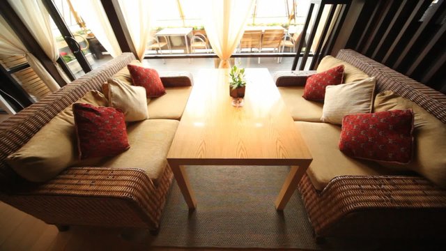 Wicker sofas stand in restaurant lounge