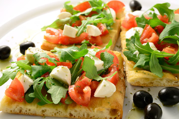 Focaccia with tomatoes, rocket, mozzarella and olives