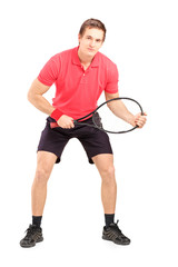 Full length portrait of a male tennis player holding a racket