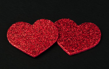 Red shiny hearts on black background