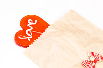 Heart shaped lollipop in bag on white. Valentine's sweet heart