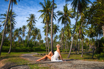 Fototapeta na wymiar girl in white dress with palms
